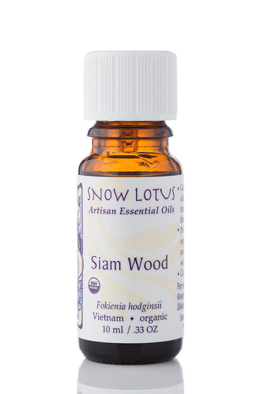Snow Lotus organic Siam Wood Essential Oil in an amber glass bottle